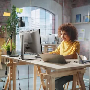 ALOGIC Clarity Max 32-tommers 4K-skjerm på et justerbart stativ i et lyst kontorarbeidsområde