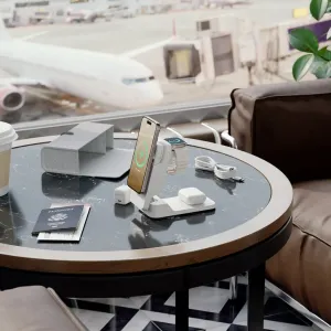 ALOGIC Matrix ULTIMATE kabelloses 3-in-1-Ladegerät mit Smartphone, Uhr und Ohrhörern auf einem Reisetisch