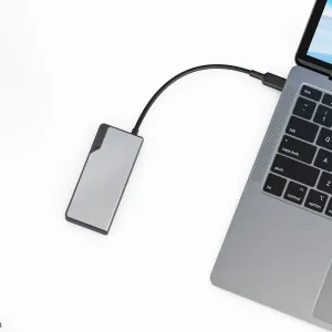 Hõbedane Alogic USB-C jaotur, mis on ühendatud sülearvutiga mitme pordiga ühenduvuseks