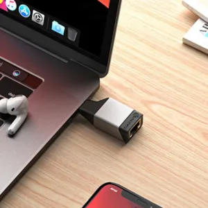 ALOGIC Ultra Mini USB-C–RJ45 Gigabit Ethernet -sovitin liitettynä kannettavaan tietokoneeseen puisella pöydällä