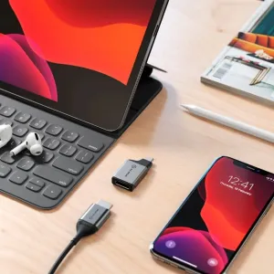 ALOGIC Ultra Mini USB-C-auf-HDMI-Adapter auf einem Schreibtisch neben einem Tablet und Smartphone für die Bildschirmverbindung