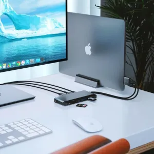 ALOGIC Dual USB-C Super Hub ansluten till en bärbar dator och en skärm på ett skrivbord, med ett minneskort isatt.