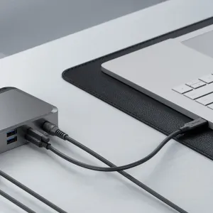 ALOGIC PRIME MX2 Universal-Dock, angeschlossen an einen Laptop, mit USB-A-Anschlüssen und mehreren Kabeln auf einem Schreibtisch.