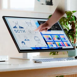 ALOGIC Clarity 6K-Touchscreen-Monitor auf einem Standfuß, mit einer Hand, die das Display für Designarbeiten nutzt.