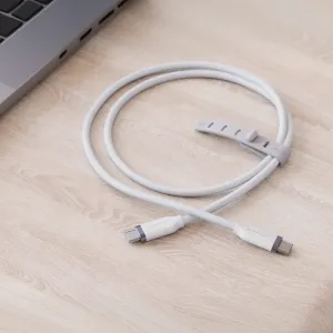 Câble de charge USB-C vers USB-C blanc Alogic avec attache-câble, présenté enroulé sur un bureau à côté d’un ordinateur portable.