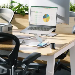 ALOGIC Elite Power-ställ för bärbar dator med trådlös laddningsplatta, visat med en bärbar dator och en telefon på ett skrivbord.