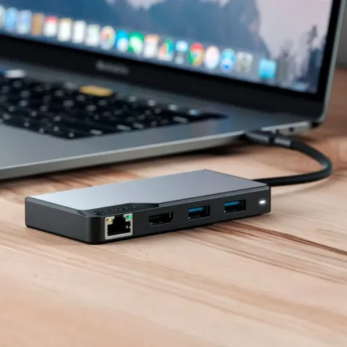 ALOGIC USB‑C 5‑i‑1 rymdgrå hubb på skrivbord, ansluten till bärbar dator; portar synliga: Ethernet, HDMI, två USB‑A och LED.