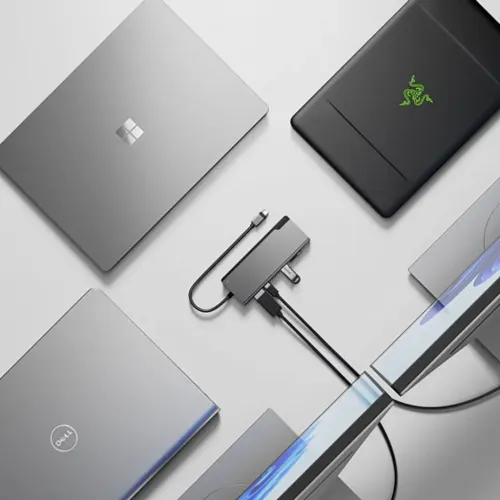 ALOGIC Ultra USB-C Dock PLUS V2 i rymdgrått, kompakt rektangel med fast USB‑C-kabel och HDMI- och USB-portar, ansluten till två skärmar på bord.