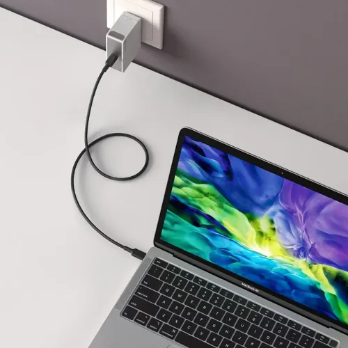 ALOGIC USB‑C väggladdare i vägguttag, rektangulär silver med ansluten USB‑C‑kabel som laddar en bärbar dator på skrivbord