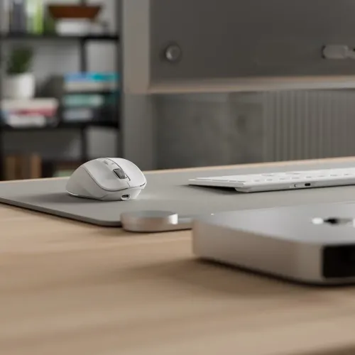 ALOGIC APEX hiir skulptuurse kujuga, kerimisrattaga, kahe pöidlanupuga ja esipoolse USB-C pordiga hiirepadil laua klaviatuuri kõrval.