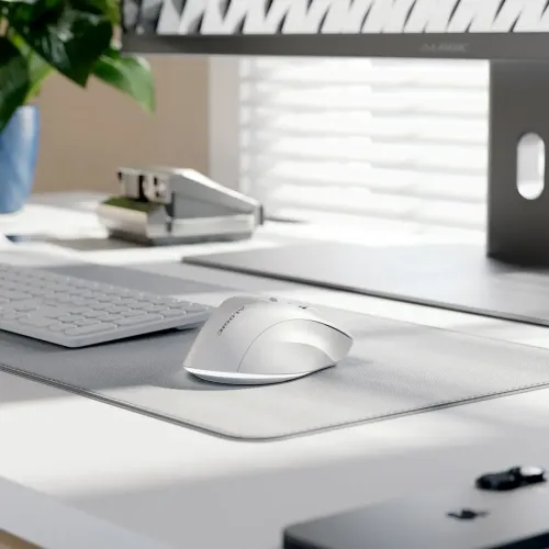 ALOGIC APEX hvit ergonomisk trådløs mus på en skrivebordsmatte, vist med tastatur i et moderne arbeidsområde.