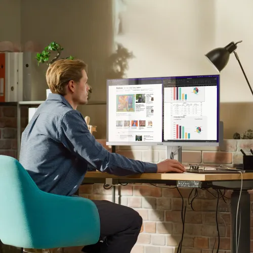 ALOGIC EDGE 34-tommers ultrabred skjerm på en arbeidsplass, med nettsider og diagrammer i delt skjerm
