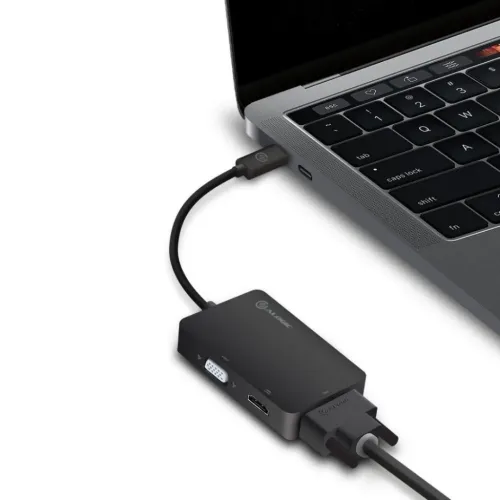 ALOGIC 3-in-1 USB-C adapteris, kas savienots ar klēpjdatoru, ar redzamām pieslēgvietām: HDMI, VGA un DVI, kur DVI kabelis ir skaidri pievienots.