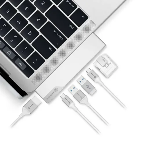 Station d’accueil ALOGIC Ultra USB-C Dock NANO Gen 2 à côté d’un ordinateur portable, avec des câbles USB et des cartes mémoire sur une surface blanche