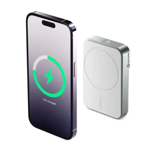 ALOGIC baltos spalvos stačiakampio formos su magnetiniu žiedu ir LED indikatoriumi, rodomas šalia telefono su žaliu įkrovimo simboliu.