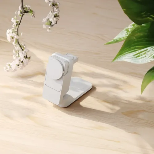 langaton 3-in-1-laturi, valkoinen, jossa on magneettinen puhelinlevy, etupuolella oleva kellokiekko ja jalustassa oleva alalevy, vaalealla puupinnalla.