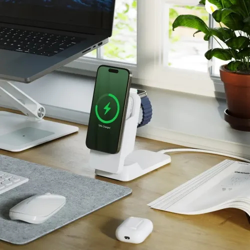 Valkoinen 3-in-1 langaton laturi, jossa on seisova puhelin, sivulle asennettava kelloteline ja kuulokelevy pohjassa, kaapeli takana.