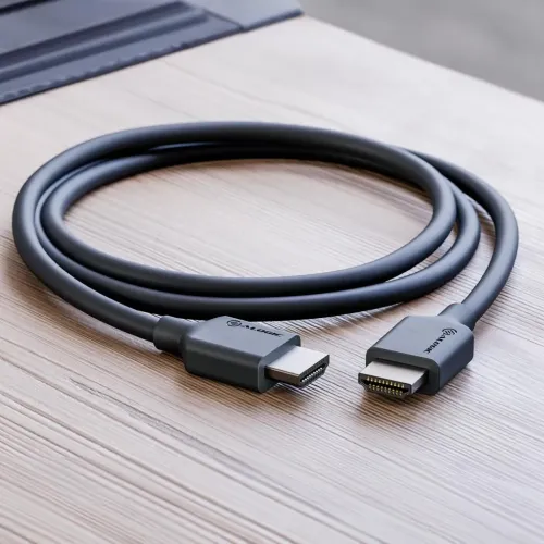 ALOGIC HDMI‑kabel hane‑till‑hane i svart med lågprofilgjutna kontakter och synlig logotyp, upprullad på ett ljust träbord.
