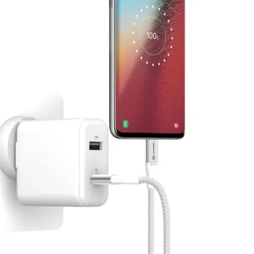 Flätad silverfärgad USB-C till USB-C-kabel kopplad mellan väggladdare och smartphone; rak kontakt och kort kabel syns.