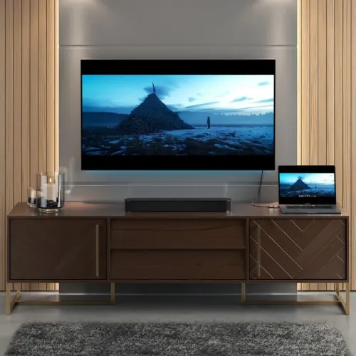 Alogic Ultra Mini USB-C-til-HDMI-adapter som kobler en bærbar PC til et TV-apparat i et hjemmeunderholdningsoppsett
