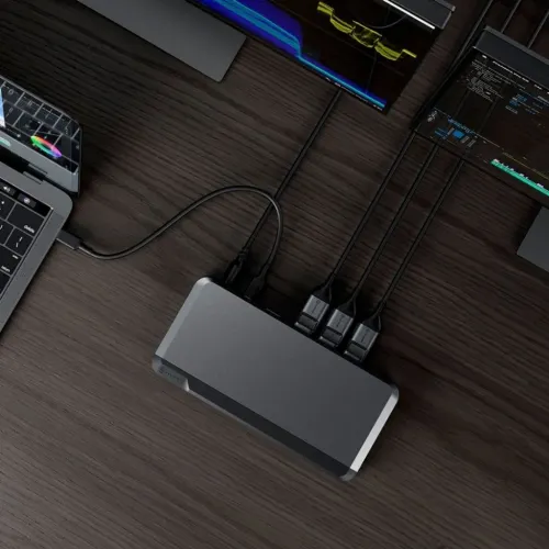 ALOGIC Prime DX3-docka i metallgrått på skrivbord, med USB‑C till bärbar dator och tre anslutna skärmkablar på ovansidan.