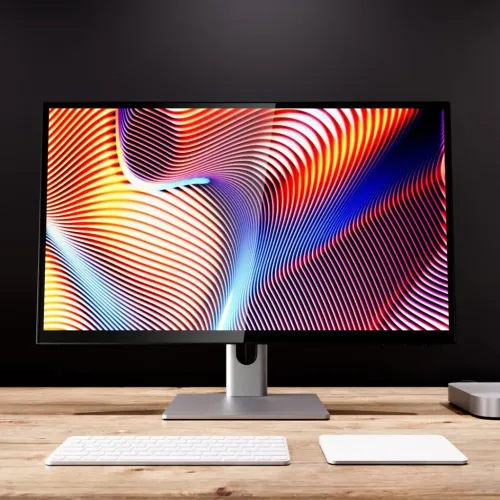 ALOGIC Clarity 27-inch UHD 4K monitor on a silver stand with colorful display, on a desk with keyboard and trackpad.