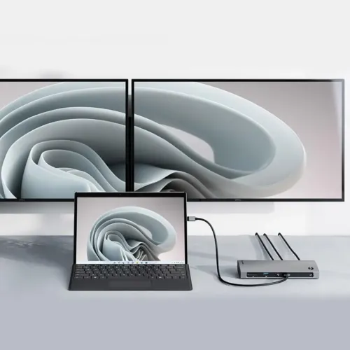 Dockningsstation i rymdgrå aluminium, ansluten till bärbar dator och två skärmar; front med SD-kortläsare, USB-A och ljuduttag