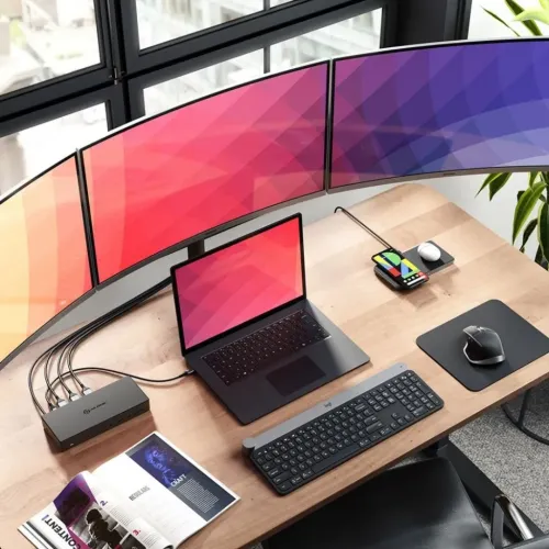 ALOGIC USB-C-dock på skrivbord; svart enhet med frontade USB-portar och ljuduttag, ansluten till laptop och tre skärmar.