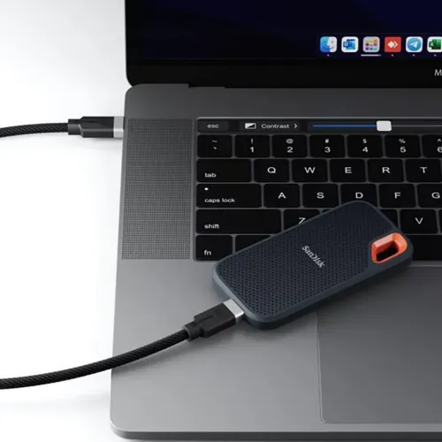 USB-C laidas su juodu pintu apvalkalu, jungiamas tarp nešiojamojo kompiuterio ir išorinio SSD disko, su pilkos spalvos mažomis metalinėmis jungtimis.