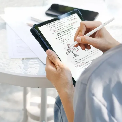 ALOGIC iPad-stylus i vitt hålls i hand och används mot en iPad-skärm med anteckningar och skiss; slank cylindrisk form, matt yta.