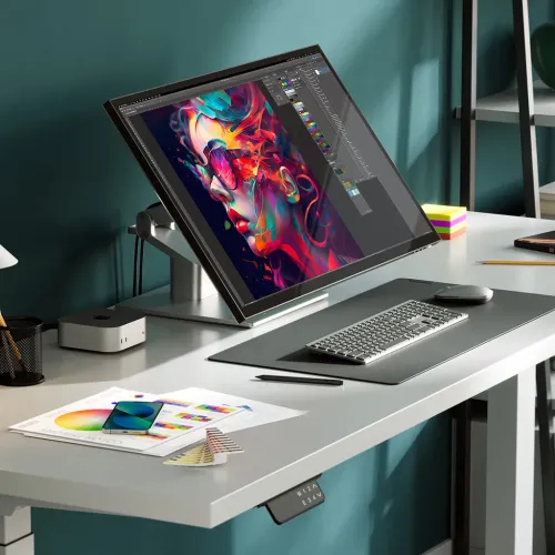 Alogic Clarity 6K skārienekrāna monitors uz salokāma statīva uz galda, ekrānā attēlojot digitālās mākslas darba vidi