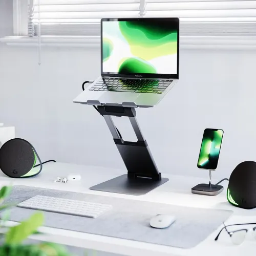 Justerbart laptopstativ i aluminium på skrivbord, höjdjusterat i Z-led med två gångjärn och framkantstöd med silikonpads.