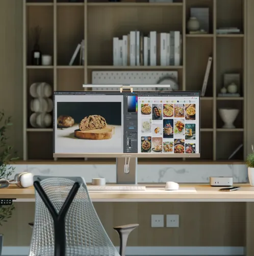 Silverfärgad ljusramp med central kameramodul, slimmad profil i metall och klämfäste, monterad mitt ovanpå en datorskärm.