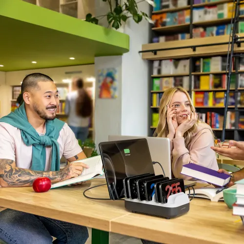 ALOGIC skrivbordsladdningsstation med tio spår, låg profil och anslutna kablar, framåtvänd logotyp, placerad på ett bord.